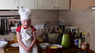 可爱的小女孩做晚餐。 小女孩在厨房准备食物。 可爱的小女孩打扮得像个厨师。